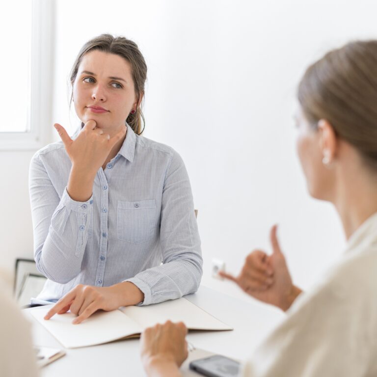 women-conversing-table-using-sign-language